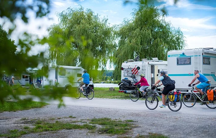 Radfahrer auf dem Radweg, dahinter Wohnmobile und der Main