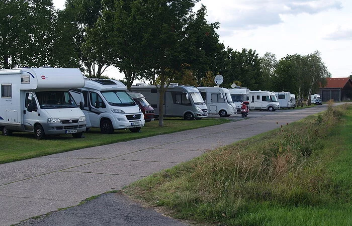 Wohnmobile auf Rasen, im Hintergrund Bäume