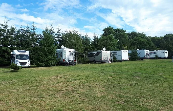 Große Wiese, am Rande Bäume und Wohnmobile