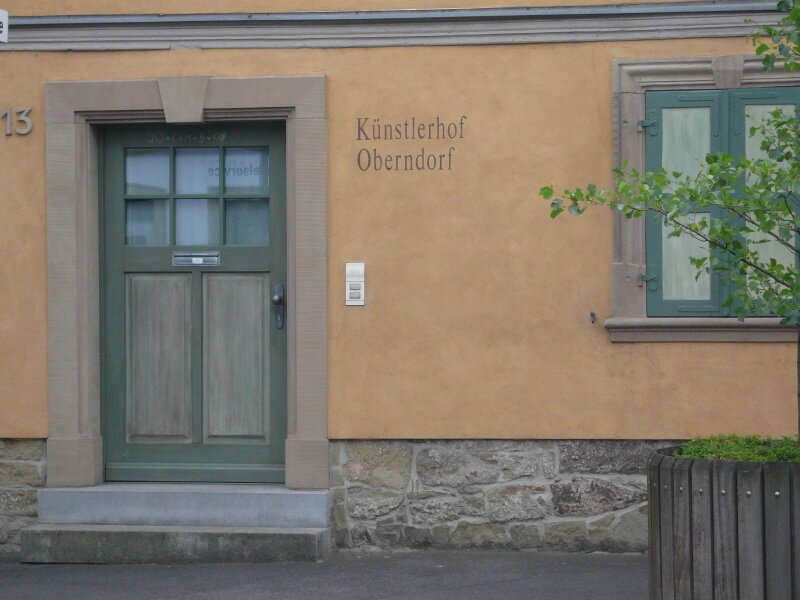 Künstlerhof Oberndorf Grüne Eingangstüre zu einem alten Haus mit grünem Fenster rechts daneben