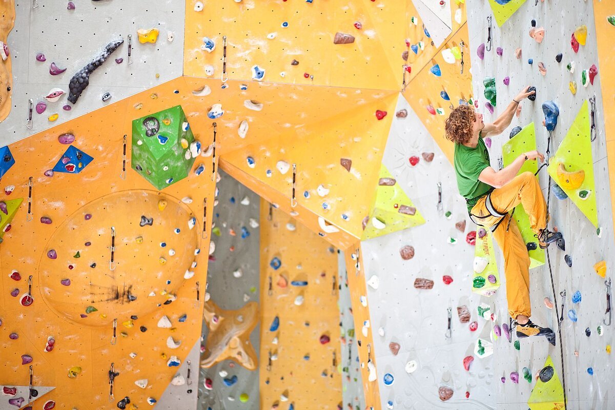 Kletterwand, gelb, orange und weiß angemalt mit vielen Greifmöglichkeiten