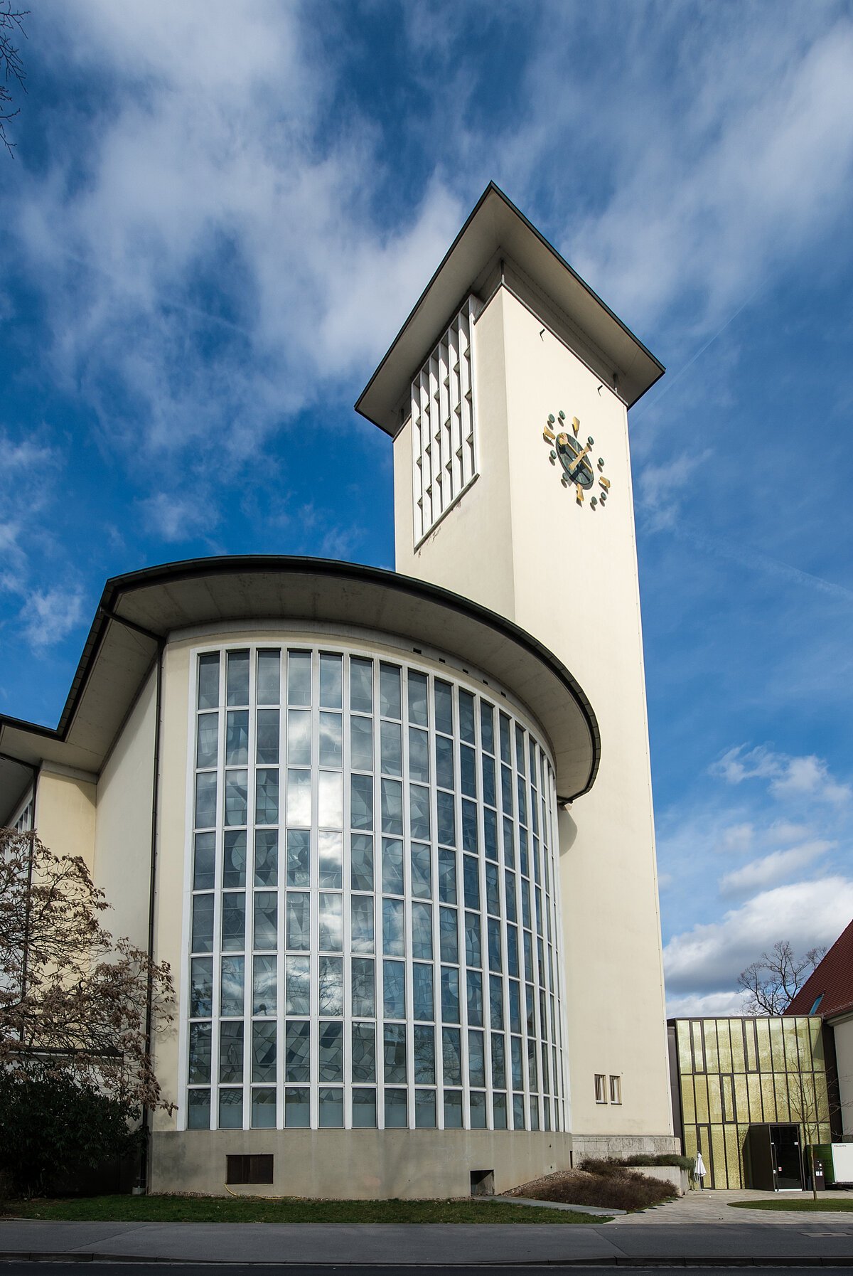Halbrundes Fenstergebäude  mit weißem Turm daneben