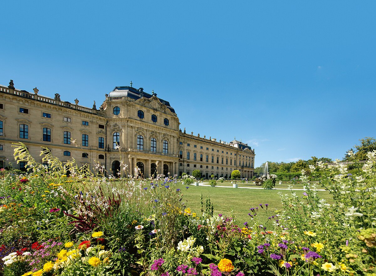 Würzburg, Residenz, Hofgarten, Ostgarten von Süden aus: Parterreflächen mit Rasen und Blumenrabatten, dahinter die Ostfassade mit Kaisersaal
