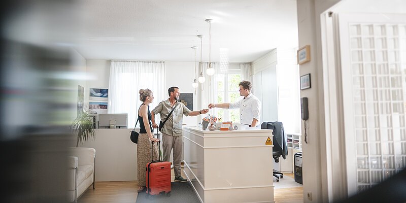 Gäste checken bei der Hotelrezeption ein