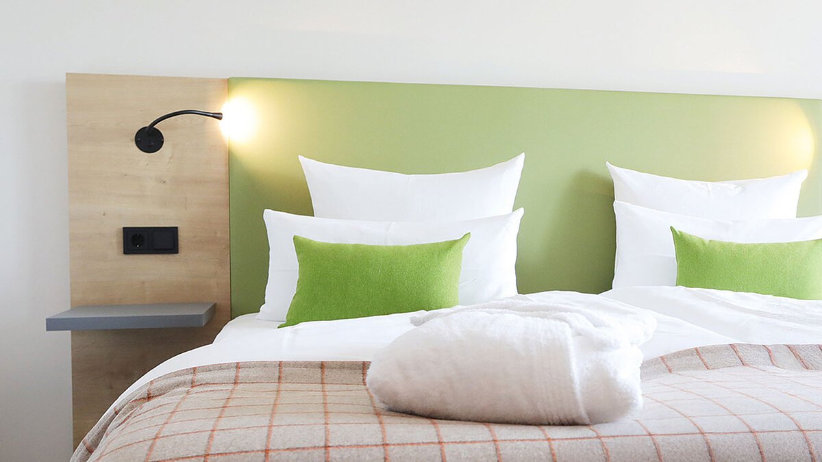 Modernes Doppelbett mit Decken und Kissen