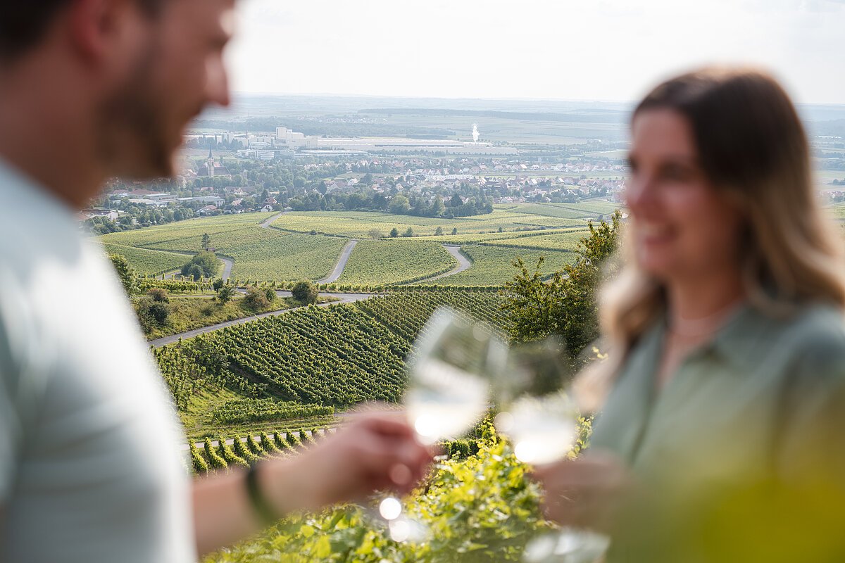 Zwei Personen trinken Wein im Iphöfer Geschichtsweinberg