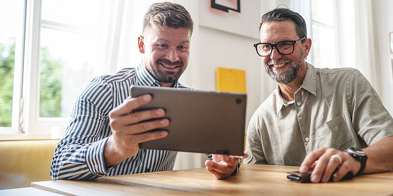 Zwei Männer schauen auf ein Tablet
