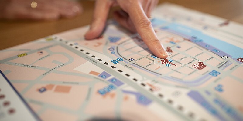 Finger zeigt auf einen Stadtplan