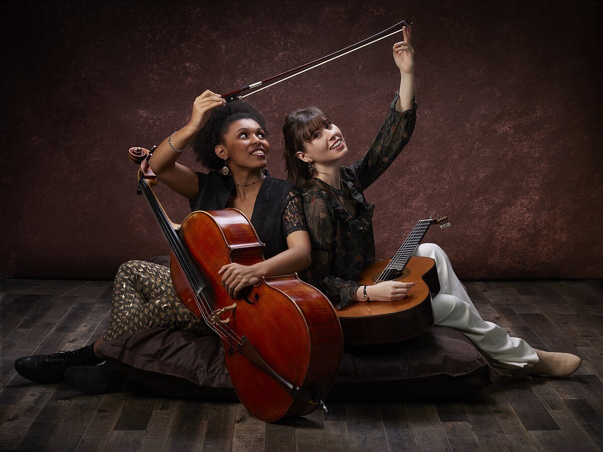 Zwei Frauen sitzend mit Musikinstrumenten in der Hand