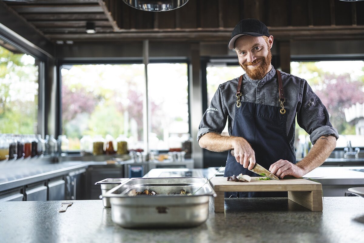 Alexander Gläsel, Küchenchef im Brückenbaron Alexander Gläsel, Küchenchef im Brückenbaron steht in seiner Küche und schneidet Kräuter