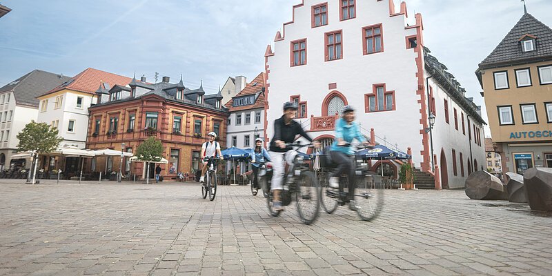 Radfahrergruppe fährt über den Karlstadter Marktplatz