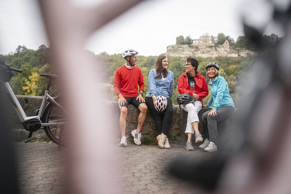 Lügenmäuerle Fahrradfahrer sitzen auf einer Mauer