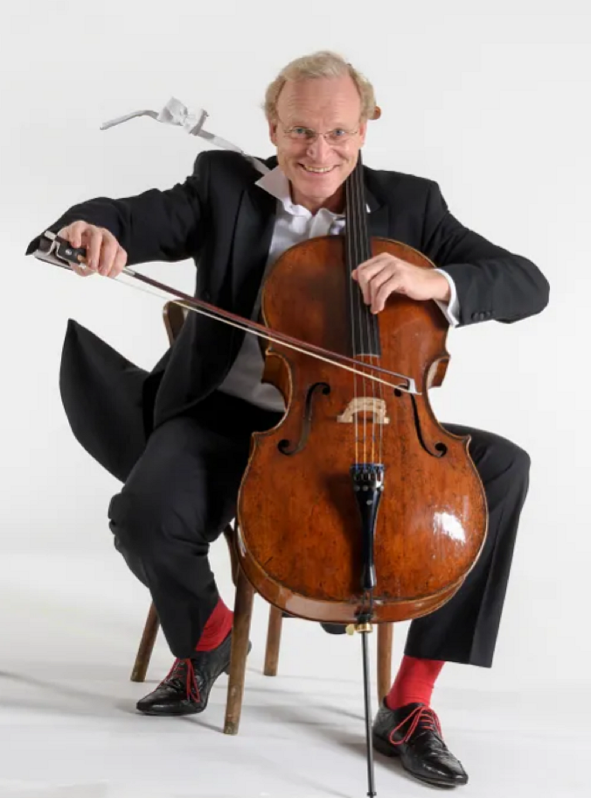 Stefan Schrader ein Mann sitz hinter einem Cello