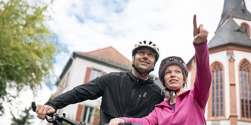 Radtouren Ein Pärchen macht eine Pause vom Fahrradfahren und die Frau zeigt auf etwas