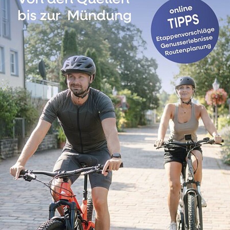 Titelbild der Radbroschüre MainRadweg. Ein paar Radelt durch einen Ort.